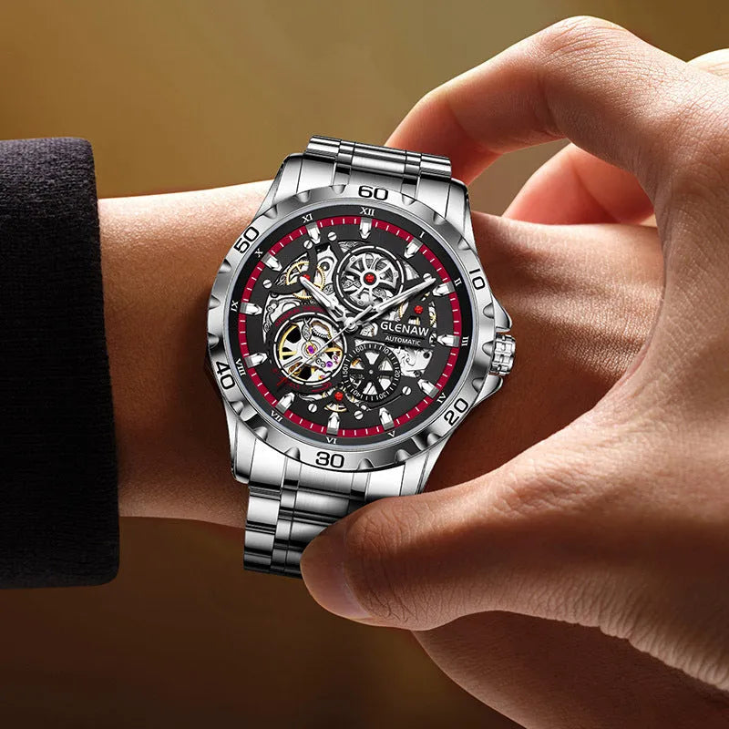 Silver men's automatic watch with hollow-out dial showing mechanics, luminous markers, and a blue stainless steel strap.