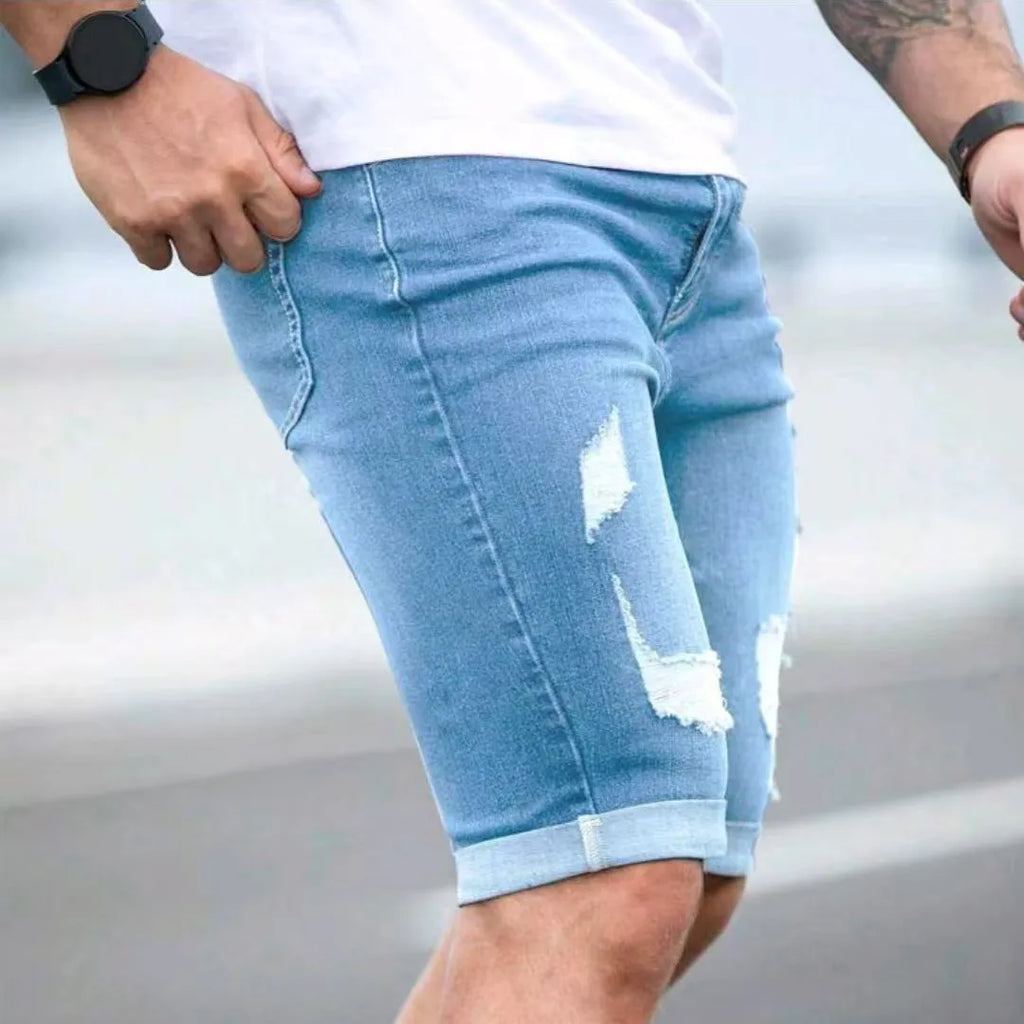 Sky blue men's denim shorts with multi-hole distressed design and low waist straight cut