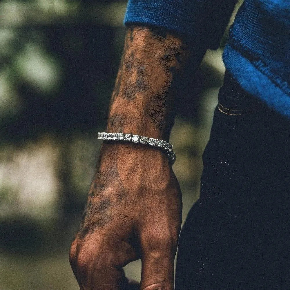 Men's silver geometric bracelet with a row of clear rhinestones and a tennis racket charm on a link chain.