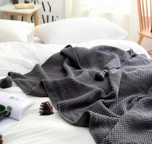 Nordic style fringed knit ball acrylic throw blanket in beige, laid flat showing 130x170cm size.