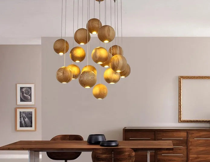 Nordic wood ball chandelier pendant light with adjustable cord, shown in a dining room setting.