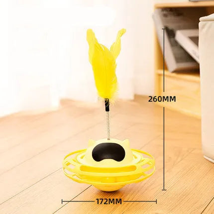 Pink plastic cat tumbler turntable toy with stick and ball on a flat surface.