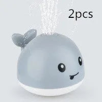 Automatic spray whale bath toy with LED lights floating in water