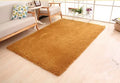 Solid colour plush rectangular area rug on floor with velvet surface and non-slip dot bottom