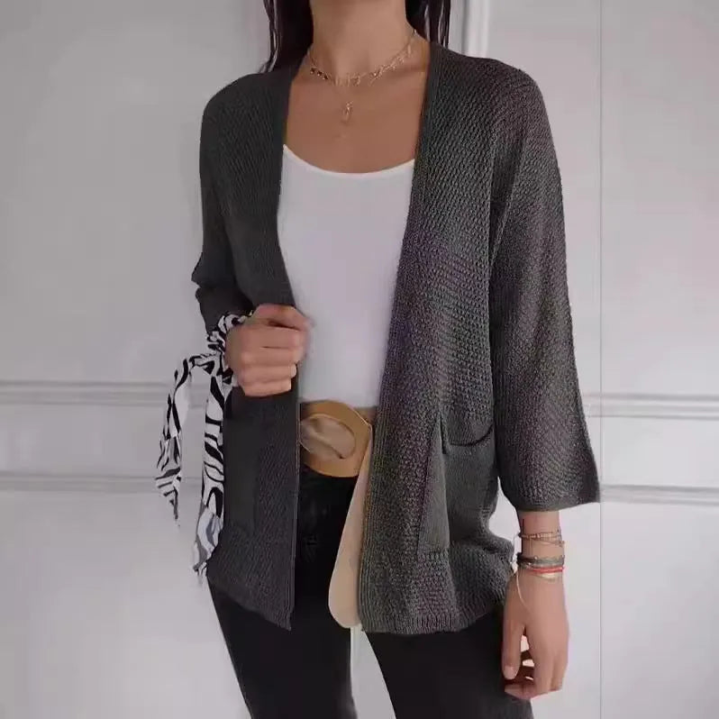 Women's army green waffle texture cardigan coat with nine-quarter sleeves and pockets on a hanger.