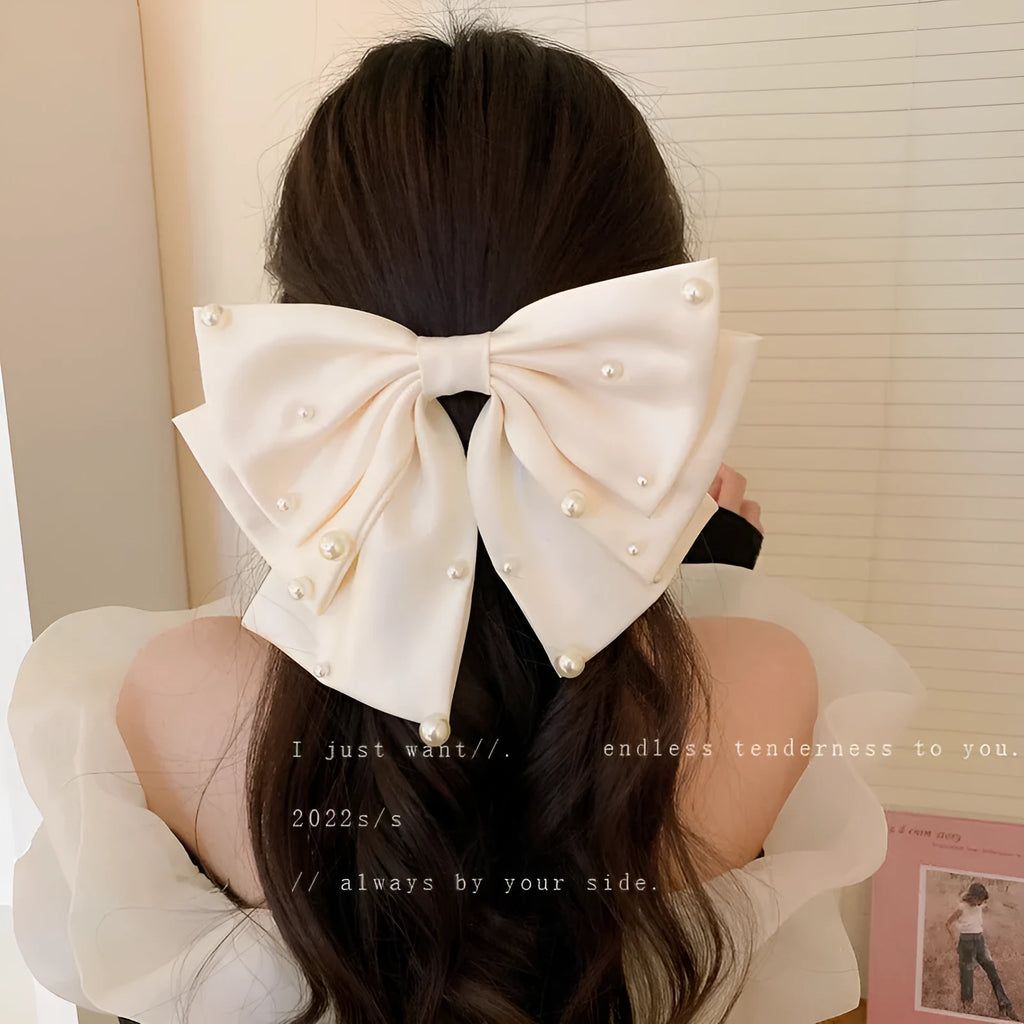 Pearl bow hair clip in black, red or beige with cloth, faux pearl and alloy construction
