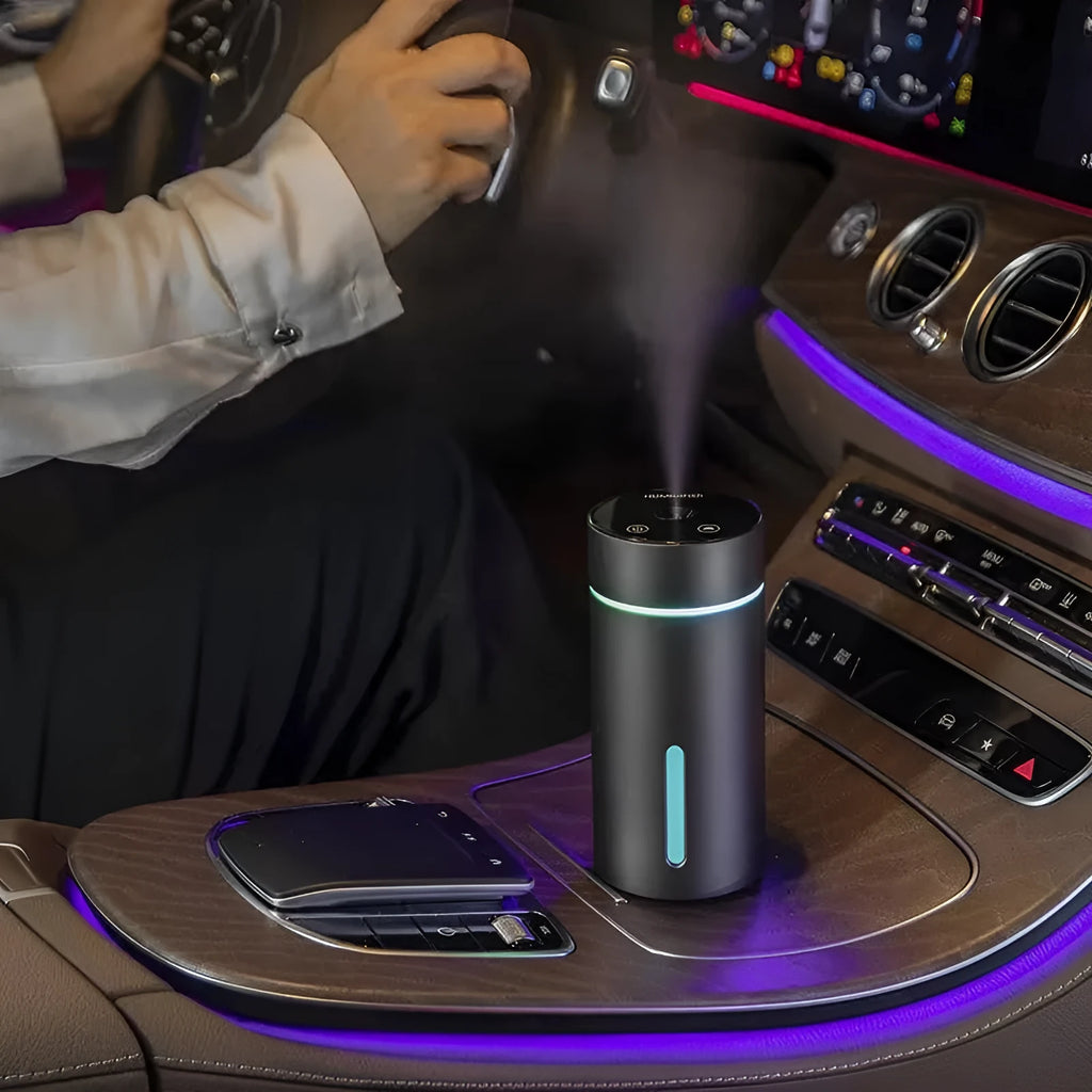 Black portable aluminium car air humidifier and essential oil diffuser with night light on a desk.