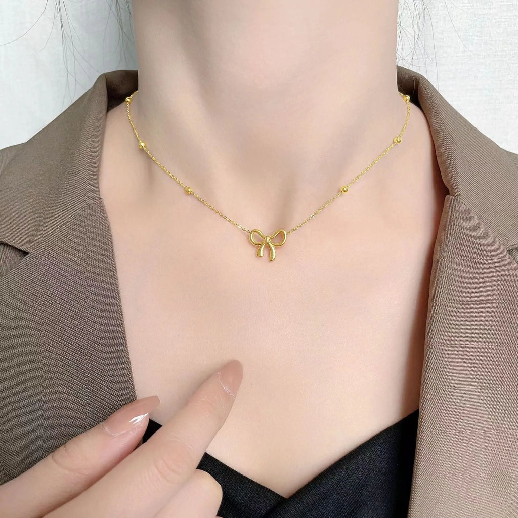 Gold electroplated bow necklace with adjustable cross chain for women