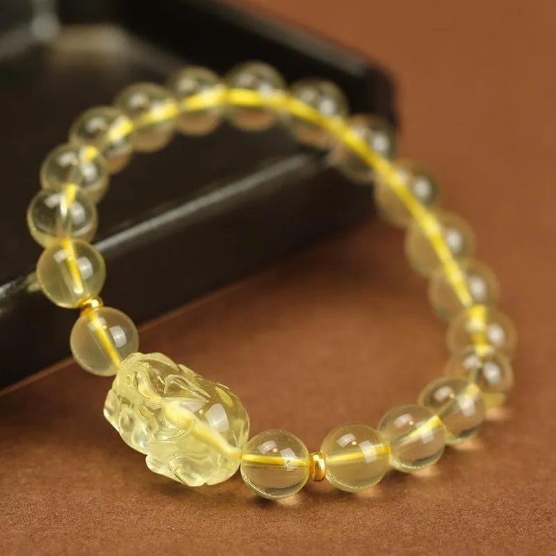 Yellow leather adjustable bracelet with a carved artificial crystal Pi Xiu charm.