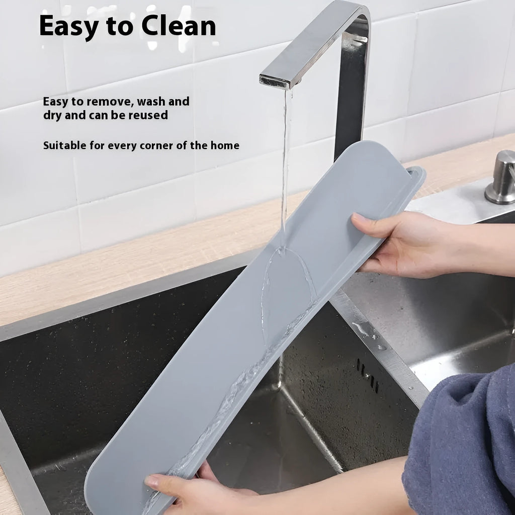 Grey silicone kitchen sink splash guard standing upright on a counter edge.