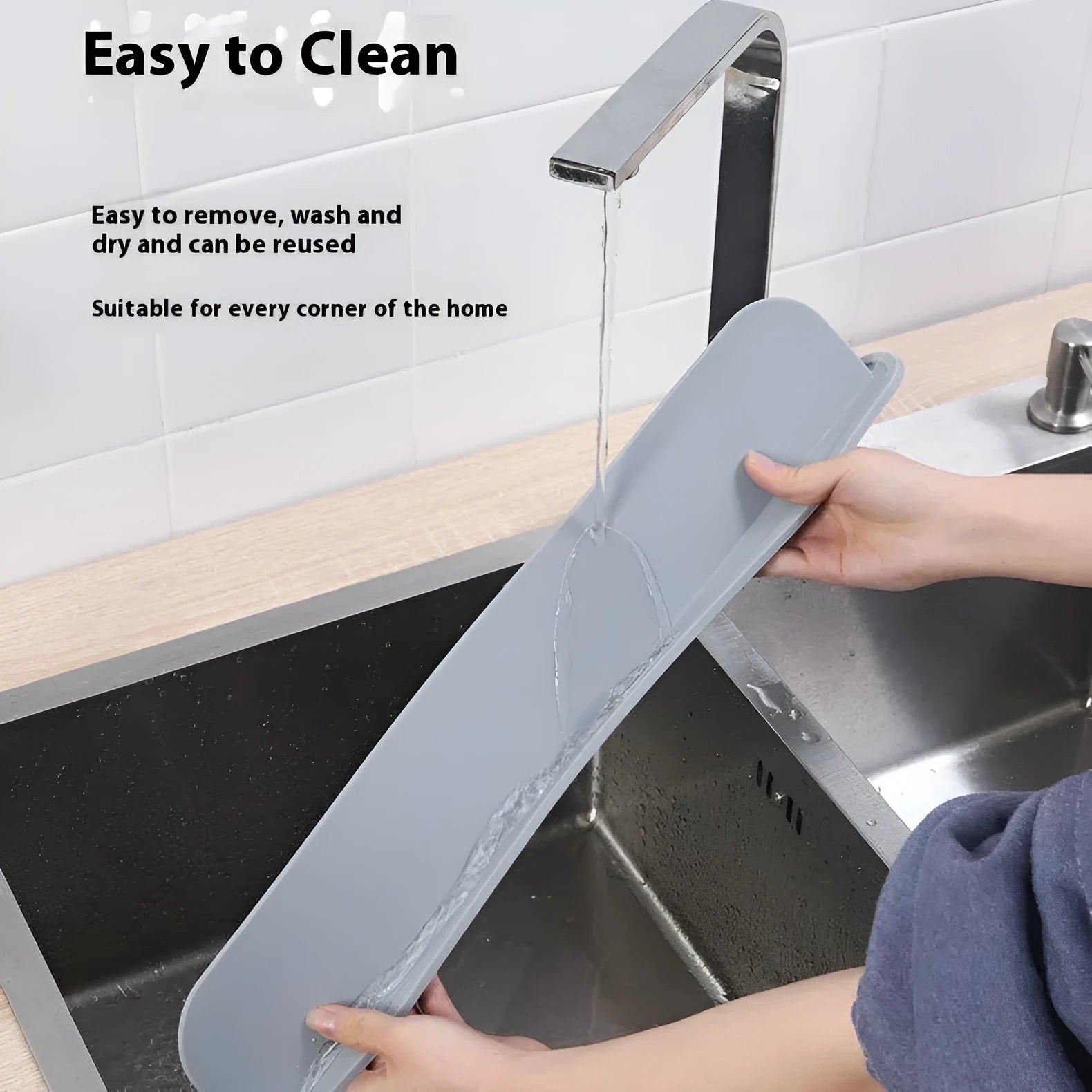 Grey silicone kitchen sink splash guard standing upright on a counter edge.
