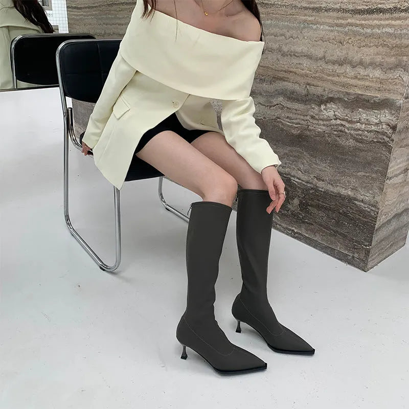 Black pointed toe women's below knee boots with stiletto heel and back zipper.
