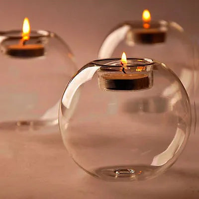 Handmade transparent round hollow glass candle holder for a tealight on a wooden table