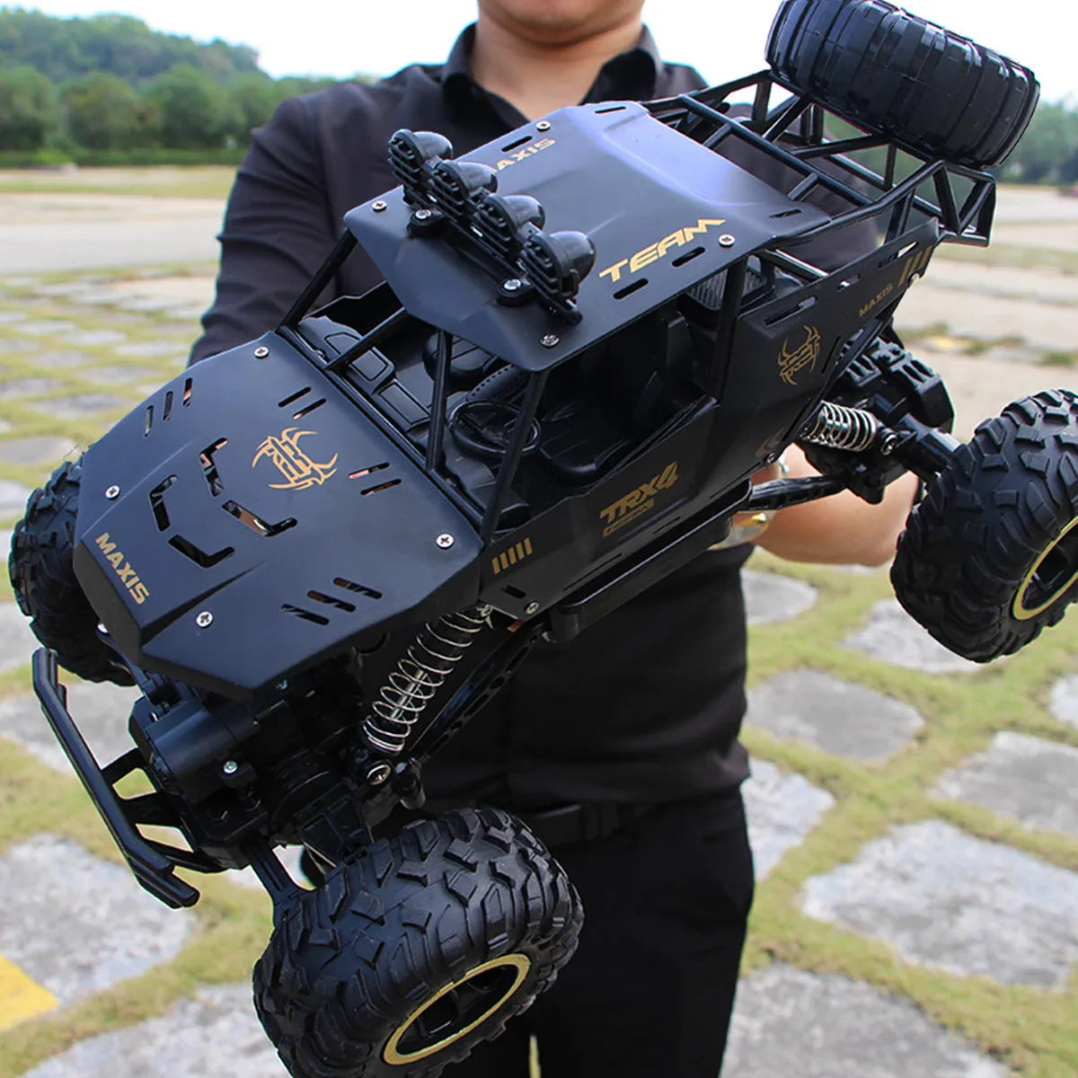 Large black 4WD remote control climbing car and a smaller silver high-speed RC car with wireless remotes