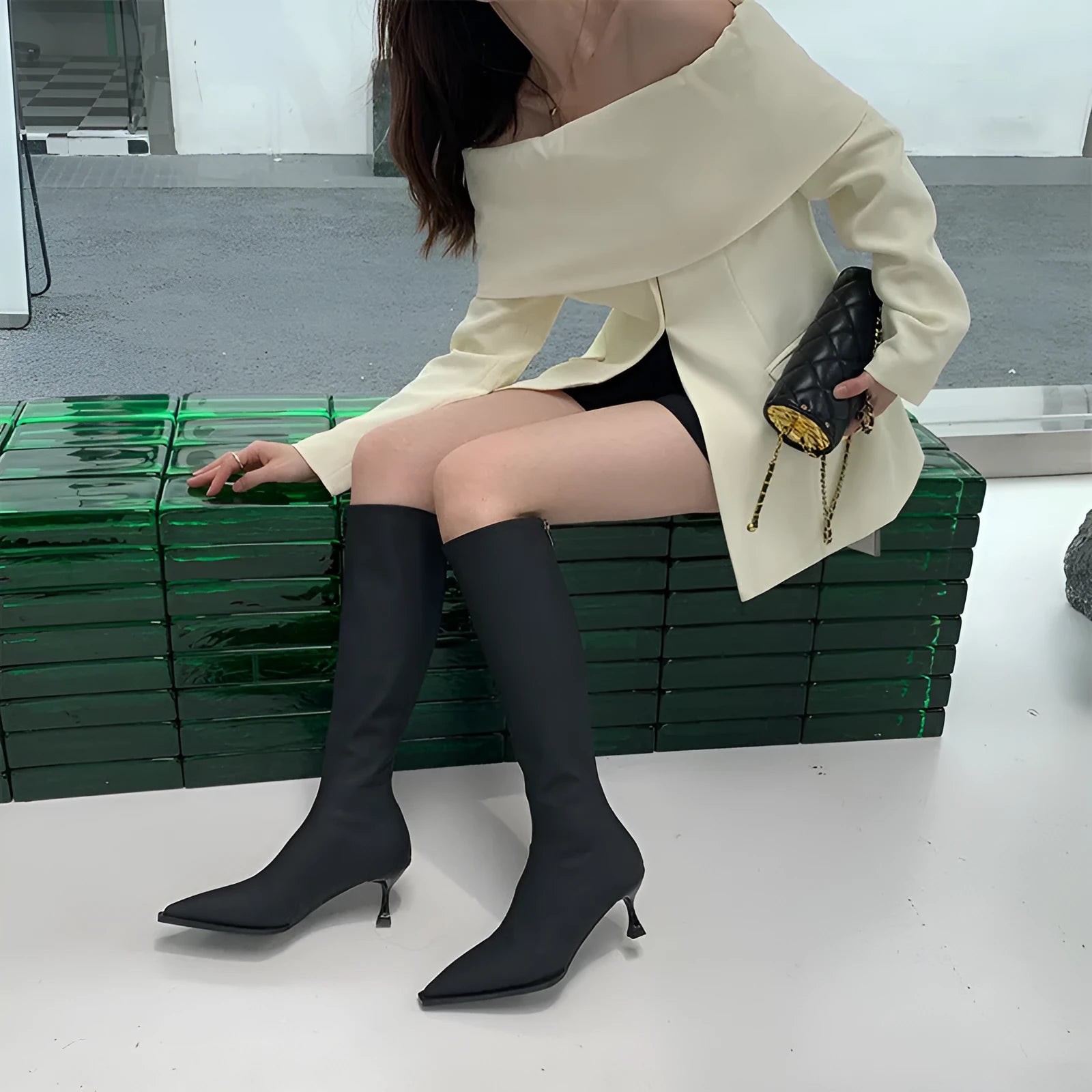 Black pointed toe women's below knee boots with stiletto heel and back zipper.