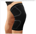 A pair of black stretch sports knee pads on a grey background, showing their non-slip design.
