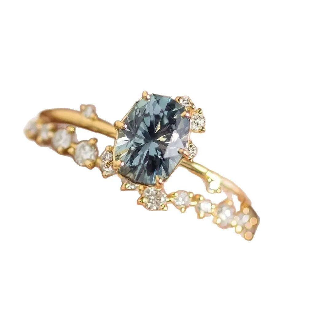 Gold-coloured floral fashion ring with a central green zircon stone on a white background.