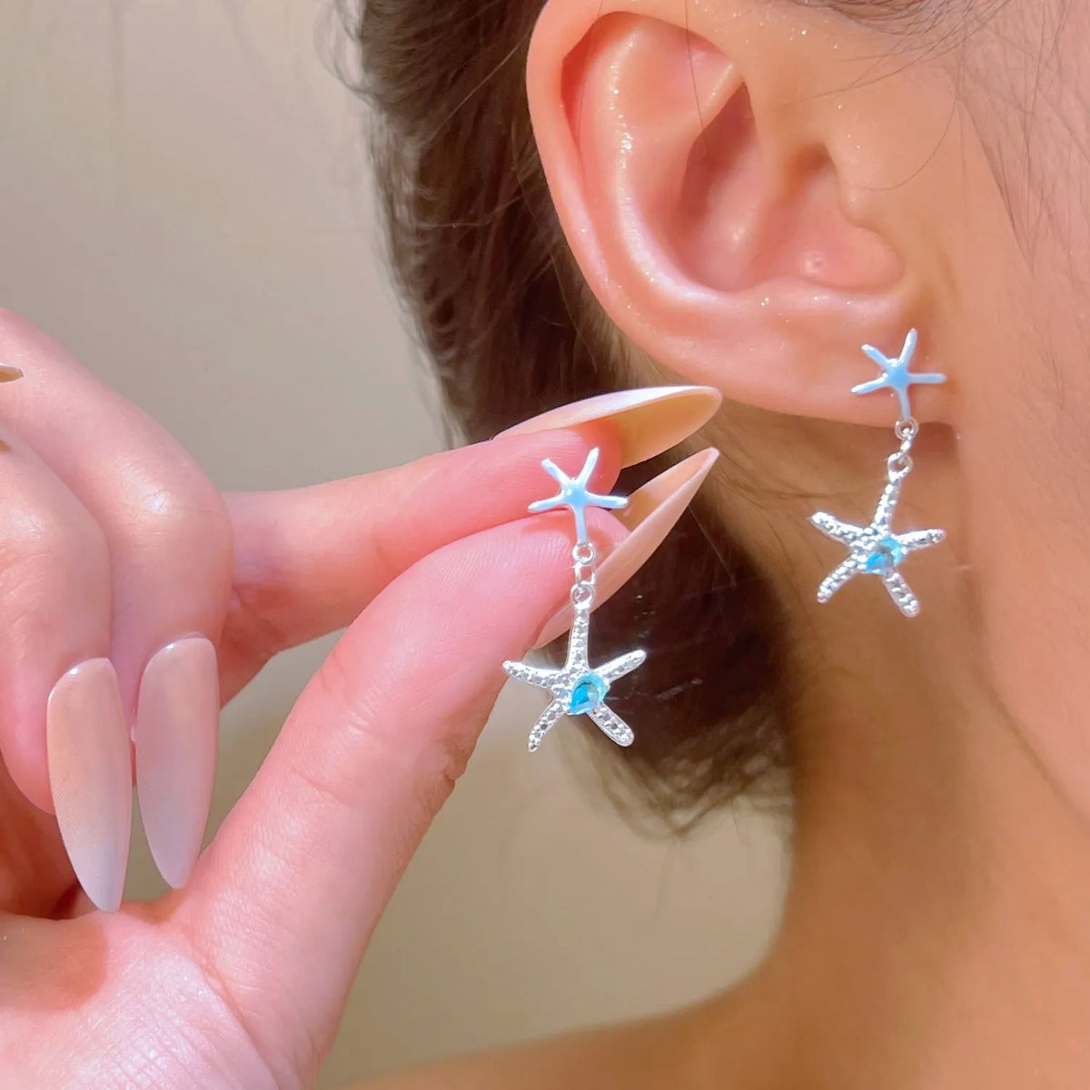 Blue zircon starfish stud earrings in a silver-tone setting with a compact design.