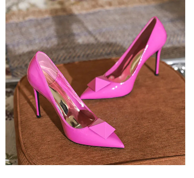 Women's pink pointed toe stiletto high heels with buckle detail on patent leather upper