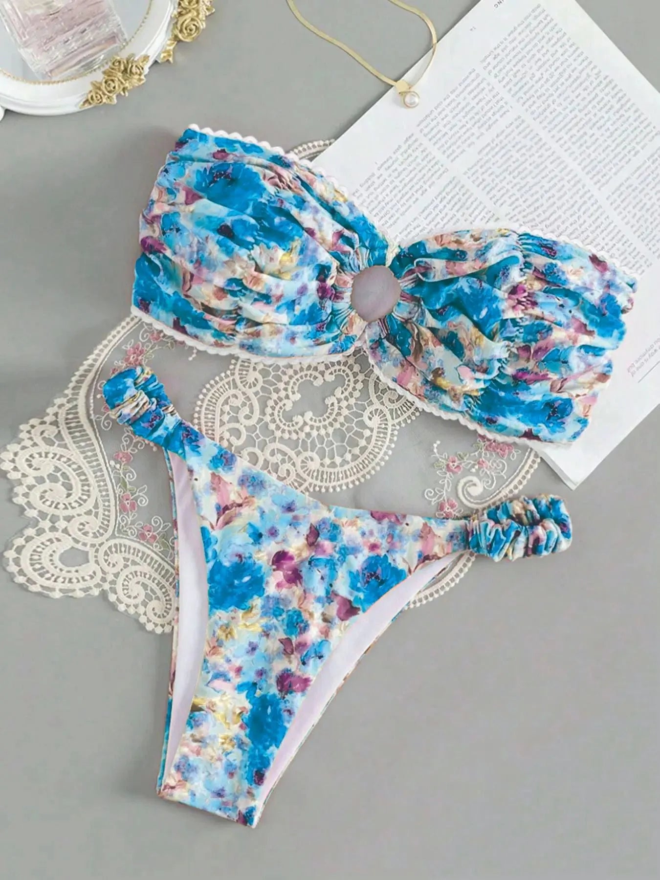 Floral print blue bikini tube top with lace trim and backless design for swimming.