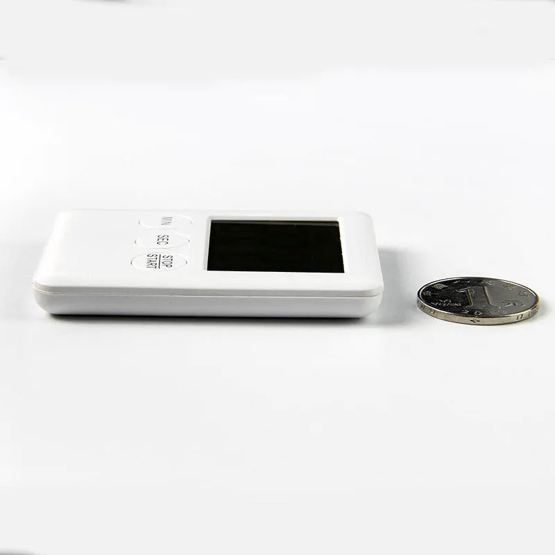 Black and white digital kitchen timer with magnetic back mounted on refrigerator