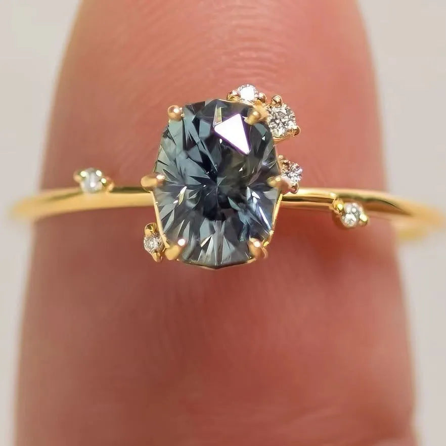 Gold-coloured floral fashion ring with a central green zircon stone on a white background.