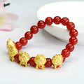 Close-up of a red agate bracelet with a carved five blessing dragon motif on 8mm beads.