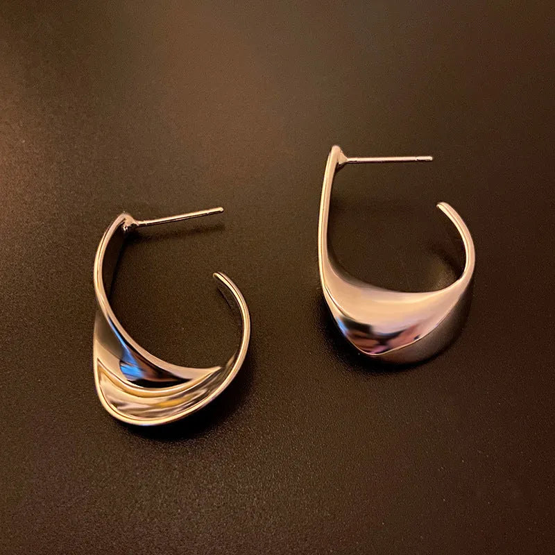 Twisted geometric metal earrings with circular elements in gold or silver electroplated finish