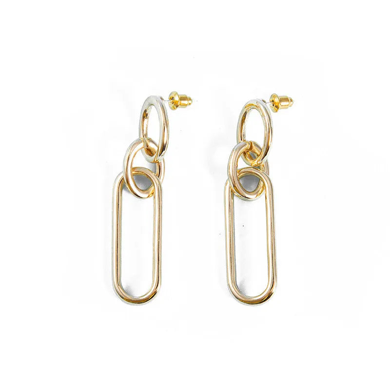 Geometric sterling silver needle hoop earrings with a line and ring design on a model.