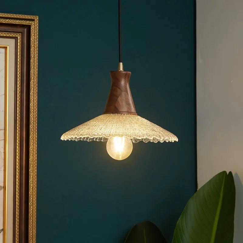 Retro wooden ceiling lamp with brass details and glass shade shown in a dining setting