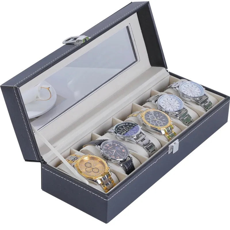 Grey leather watch storage box with transparent lid showing multiple watch slots inside.