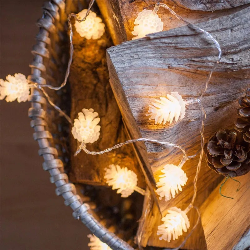 Warm white LED pine cone light string powered by AA batteries, shown in a 10-light or 20-light option for decorative use.