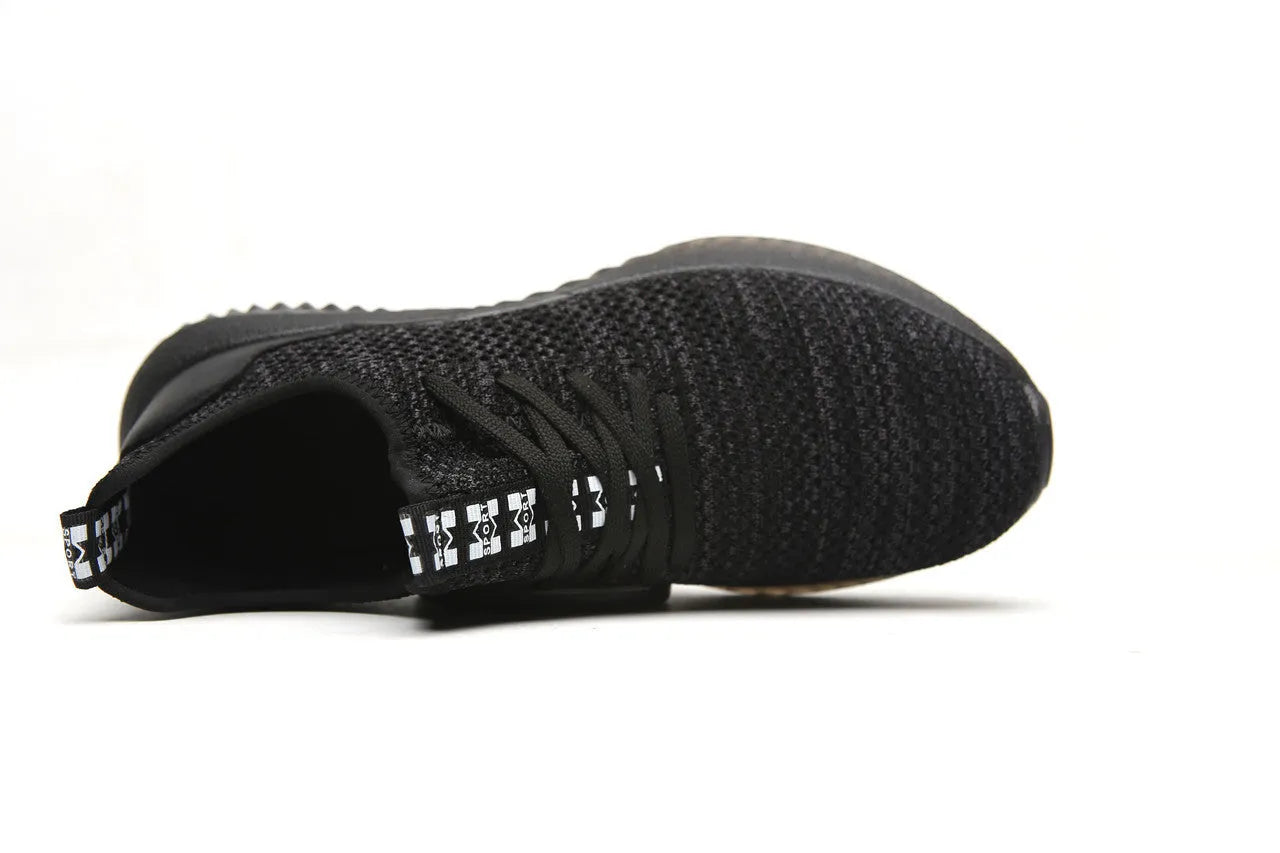 Black work safety shoe with steel toe cap and EVA sole on a grey background