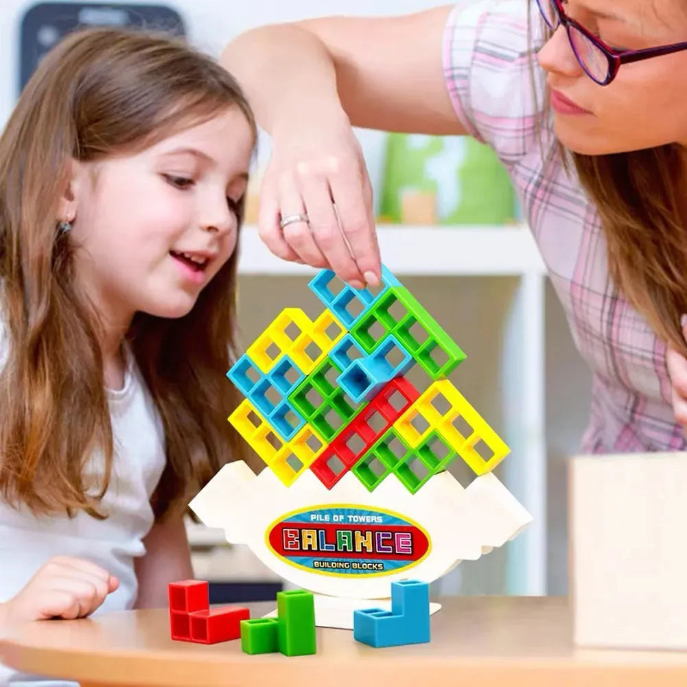 Plastic balance stacking game with 16 coloured blocks, chassis, and base on a table.