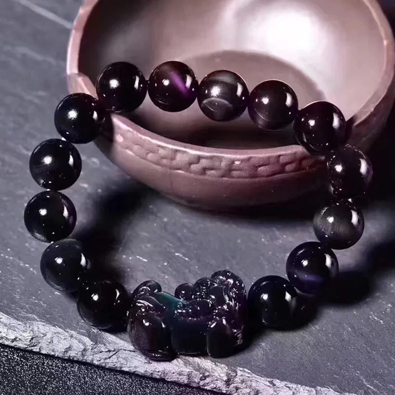 Natural eye obsidian crystal bracelet in ice colour on a wrist, showing bead sizing options.