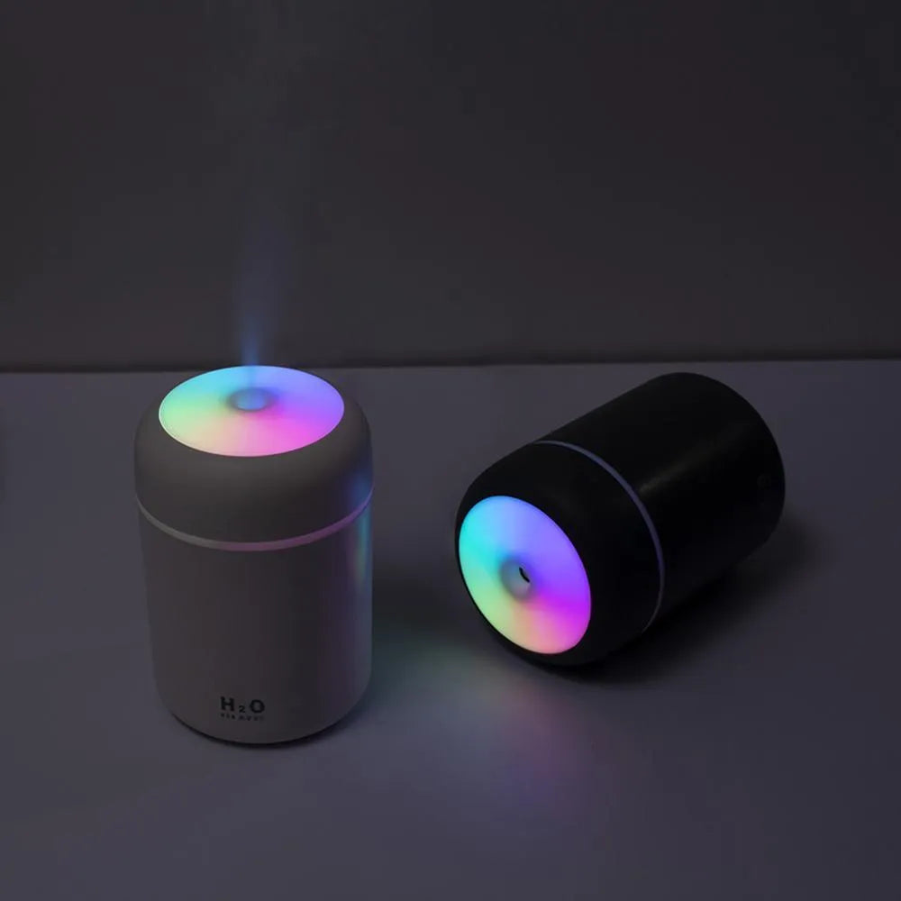 Pink, white, or navy blue USB desktop humidifier with colourful LED lights and water tank.