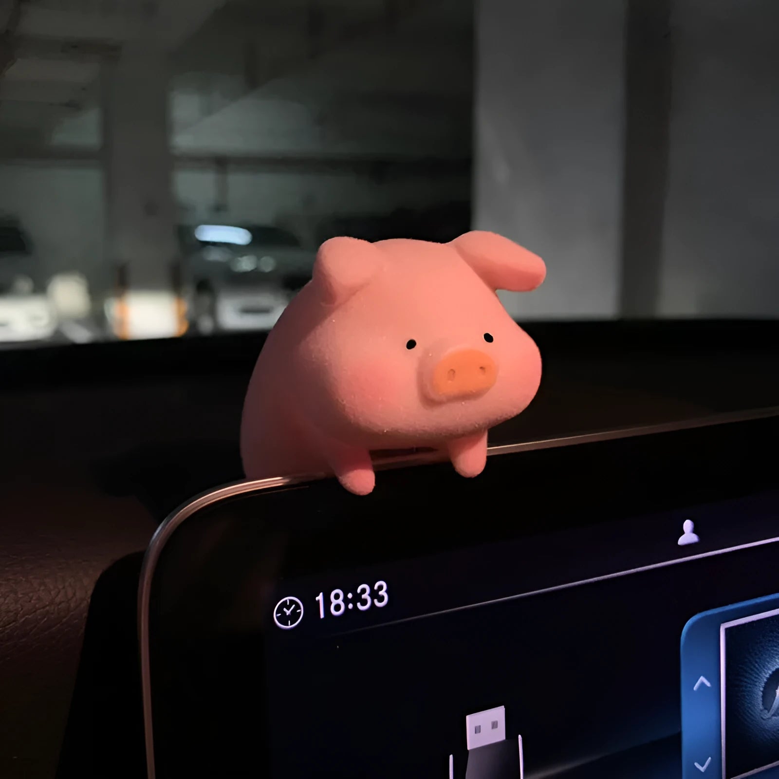 A cute resin cartoon pig figurine car dashboard decoration on a grey background.