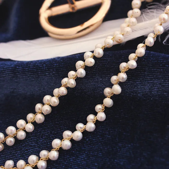 Hand-woven white pearl necklace with adjustable bean chain on display