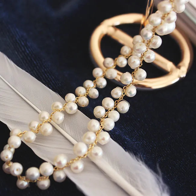 Hand-woven white pearl necklace with adjustable bean chain on display