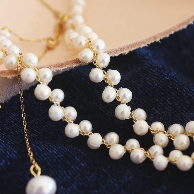 Hand-woven white pearl necklace with adjustable bean chain on display