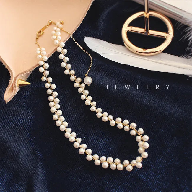 Hand-woven white pearl necklace with adjustable bean chain on display