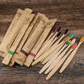 Set of 10 bamboo toothbrushes with charcoal bristles in assorted colours including white, yellow, purple, grey, green, and black