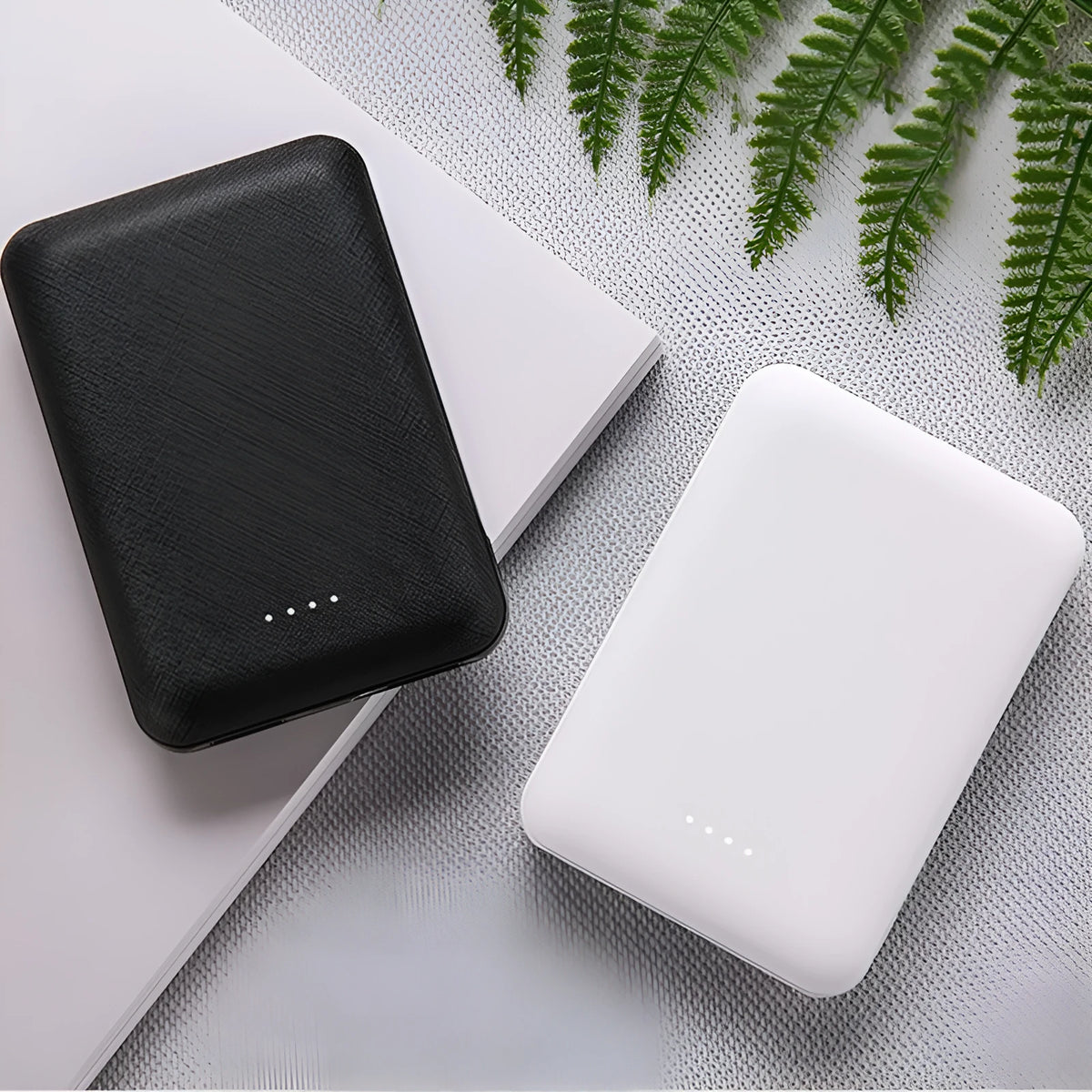 Ultra-thin black or white power bank showing multiple USB ports and 10,000mAh capacity