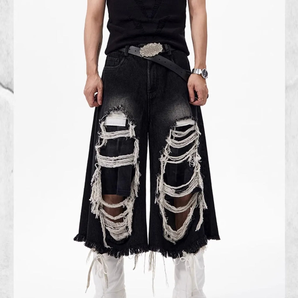 Women's black cropped wide-leg jeans with distressed patch details and mid-high waist