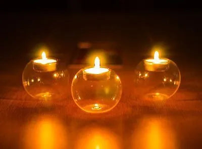 Handmade transparent round hollow glass candle holder for a tealight on a wooden table