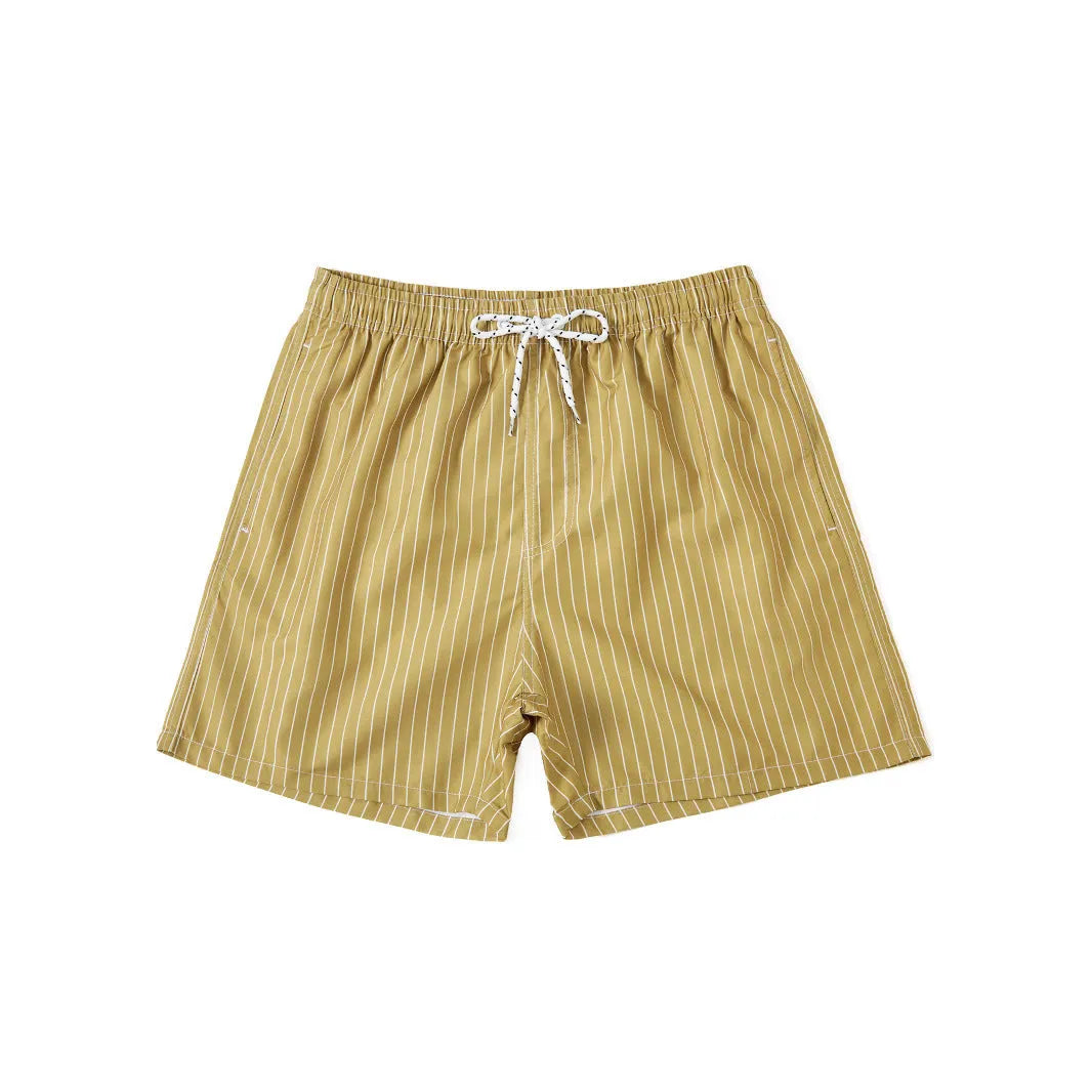 A man wearing grey striped polyester beach shorts with a straight leg opening, shown on a beach.
