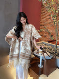 Women's tassel-trimmed scarf cape in polyester fabric shown as shawl-style accessory