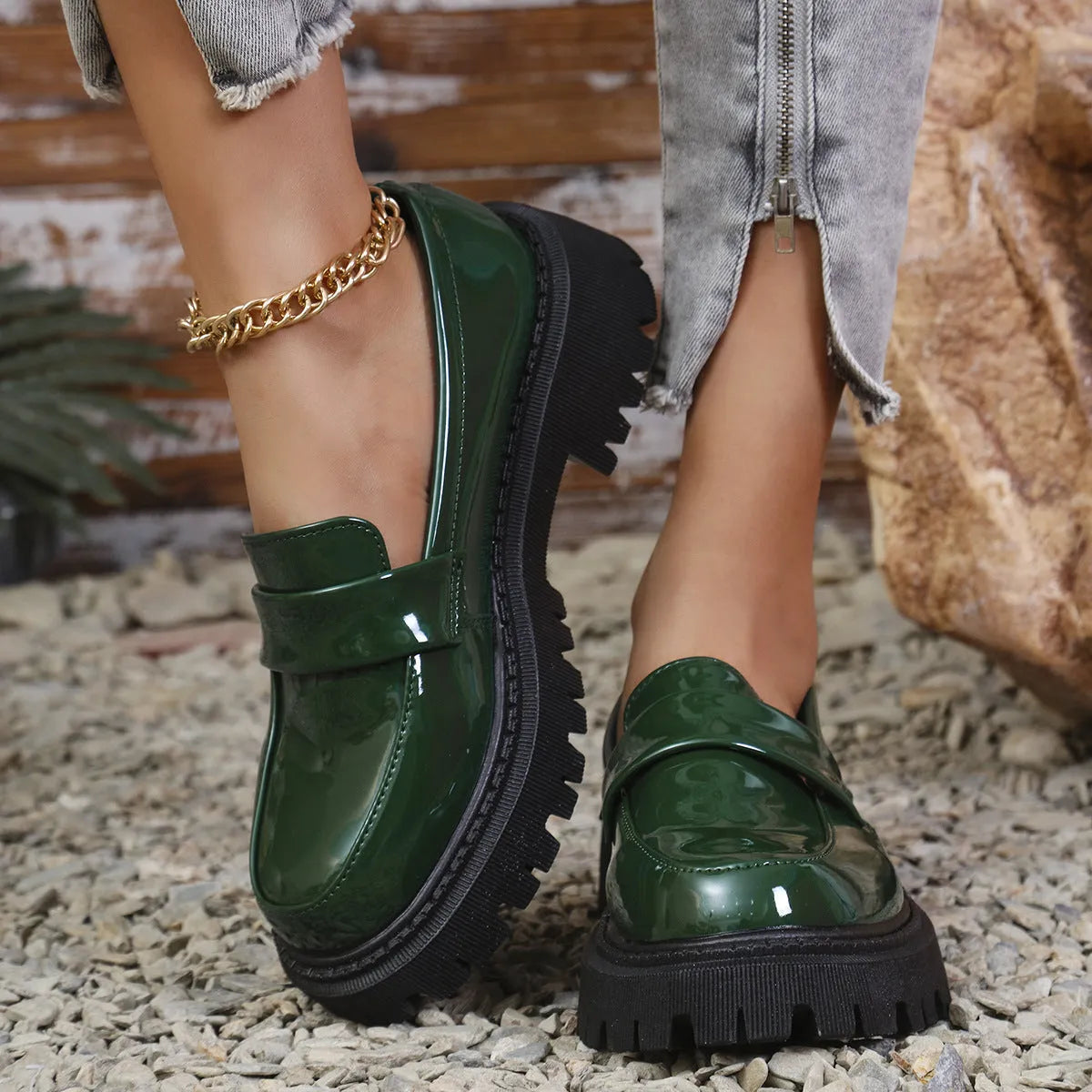 Women's black slip-on loafers with a chunky platform heel on a wooden floor