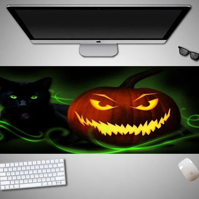 Oversized Halloween-themed gaming mouse pad on a desk, showing non-slip rubber cloth base.