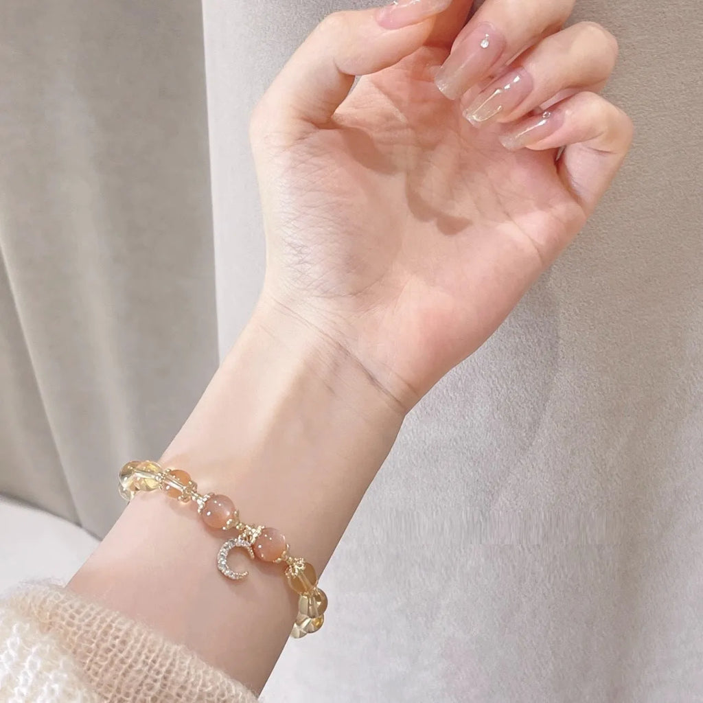 Gold electroplated women's crystal bracelet with diamond shape and fortune charm.